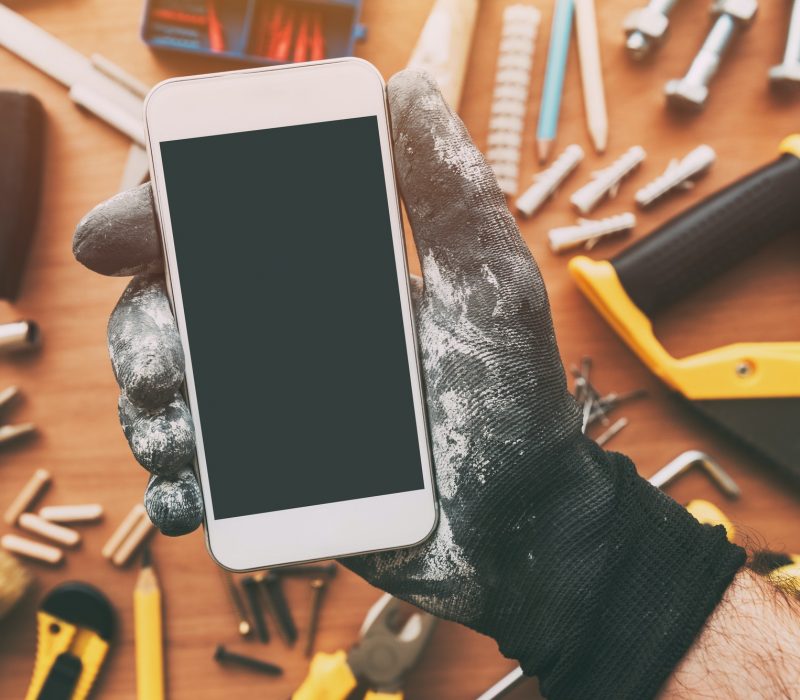 Smart phone app for handyman, repairman holding mobile phone